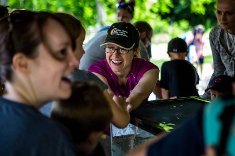 Visitors and a Des Moines County Conservation member interacting at the annual DMCC Summer Celebration.